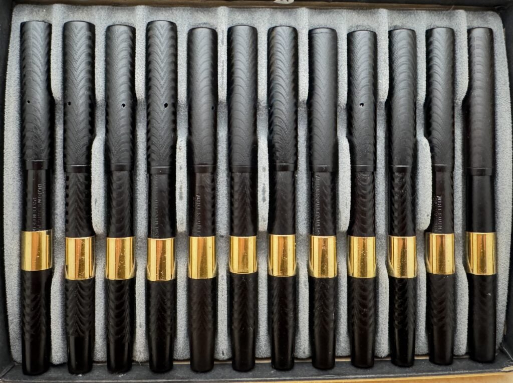The same row of vintage hard rubber fountain pens restored to deep glossy black after soaking in Dr. G's deoxidizer.